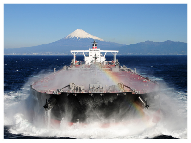 富士山を背景に、水しぶきで虹がかるコンテナ船