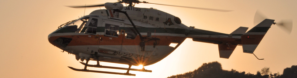 夕日を背に飛行中のヘリコプター